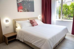 a bedroom with a white bed and a window at Casa Marino in Sorrento