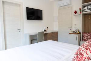 a bedroom with a bed with a television and a desk at Casa Marino in Sorrento