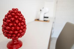 a red vase filled with red balls sitting on a table at Casa Marino in Sorrento