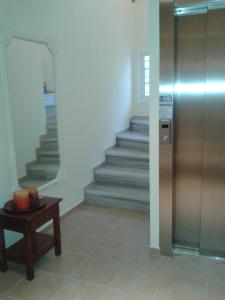 um corredor com escadas, uma mesa e um elevador em Pantheon Beach Hotel em Olympiakí Aktí
