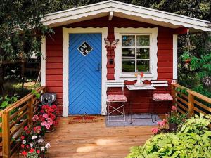 una pequeña casa roja y blanca con una puerta azul en 5 person holiday home in TOSTARED, en Tostared