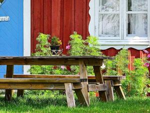 un banco de madera con macetas delante de una casa en 5 person holiday home in TOSTARED, en Tostared