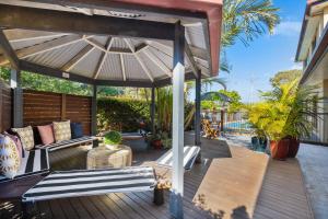 een houten terras met een tuinhuisje bij Ocean Park Motel & Holiday Apartments in Coffs Harbour