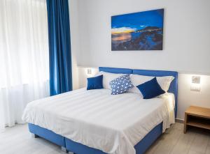 a bedroom with a blue and white bed with blue curtains at Casa Marino in Sorrento