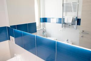 a bathroom with blue tiled walls and a mirror at Casa Marino in Sorrento