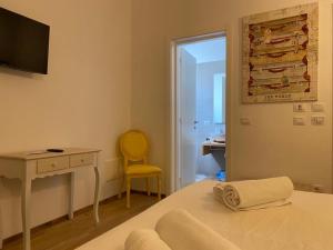 ポリニャーノ・ア・マーレにあるStorie di Mareのベッドルーム1室(デスク、ベッド1台、黄色い椅子付)