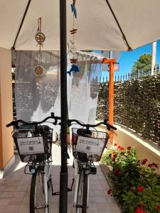 deux vélos enchaînés à un poteau sous un parapluie dans l'établissement Silvi d'aMare, à Silvi Marina
