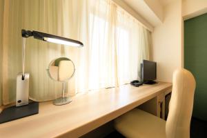 a lamp sitting on top of a desk next to a window at Daiwa Roynet Hotel Tokyo Akabane in Tokyo