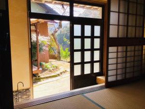 una puerta abierta con vistas al jardín en Kominkayado Netsuki no ii Kitsune - Vacation STAY 27812v en Shimanto