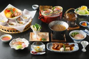 una mesa cubierta con platos de comida y tazones de sopa en Keishokan Sazanamitei en Fukuyama