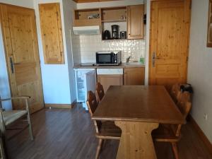 a kitchen with a wooden table with chairs and a microwave at Appartement Valloire, 2 pièces, 4 personnes - FR-1-263-399 in Valloire
