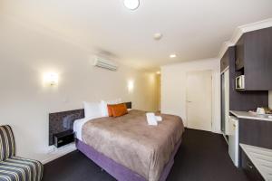 a hotel room with a bed and a desk at Dalby Fairway Motor Inn in Dalby