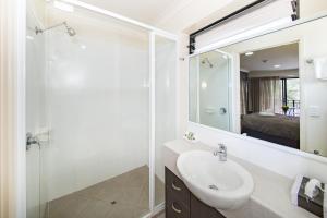 a bathroom with a sink, mirror, and shower at Dalby Fairway Motor Inn in Dalby