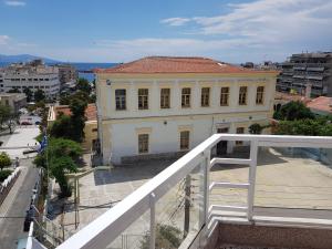 a white building with a red roof on a city street at Harmony Apartment Kavala in Kavála