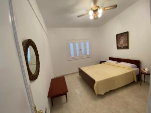 een slaapkamer met een bed en een plafondventilator bij A cheerful chalet villa few steps to the beachside in Marsa Matruh