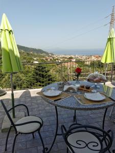 una mesa con sillas y una sombrilla en el patio en L'Angolo di Campagna, en Piano di Sorrento