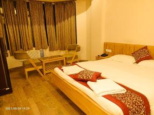 a bedroom with two beds and a table and a window at The Kingdom, Havelock in Havelock Island