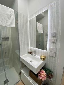 ein weißes Badezimmer mit Waschbecken und Spiegel in der Unterkunft Volto Corte Farina Apartments - Luxury Lofts in Verona