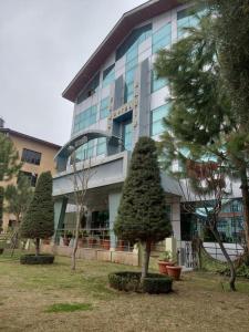 a large building with trees in front of it at Hotel Grand Habib in Srinagar