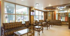 a waiting room with couches and tables and windows at Hotel Grand Habib in Srinagar
