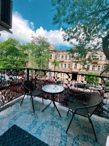 een patio met een tafel en stoelen op een balkon bij Venus Hotel Венус in Odessa