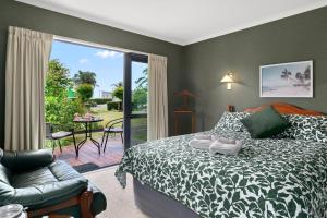 a bedroom with a bed and a sliding glass door at Tropical Avocado Orchard Escape Ohauiti in Ohauiti