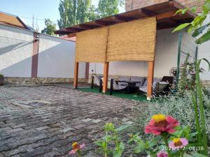 a pavilion with a table and chairs on a patio at Apartman Tia in Osijek