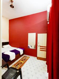 een rode kamer met een bed en een spiegel bij hari Darshan in Orchha