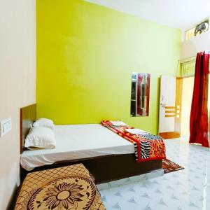 a bedroom with a bed and a green wall at hari Darshan in Orchha
