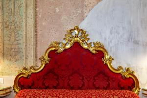un letto rosso con testiera rossa in una stanza di Locanda Casa Martini a Venezia
