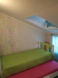 sypialnia z zielonym łóżkiem w pokoju w obiekcie Palm Garden Villa w mieście Orfánion