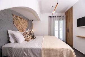 a bedroom with a large white bed with pillows at Modern Dome Homes Of Santorini in Perissa