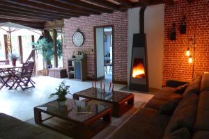 a living room with a couch and a fire place at Chambres d'hôtes et table d'hôtes L'Intemporelle in Saint Laurent Nouan