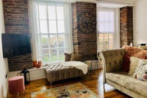 a living room with a couch and a clock on the wall at Centrally located luxury 2 bed modern apartment in Great Yarmouth