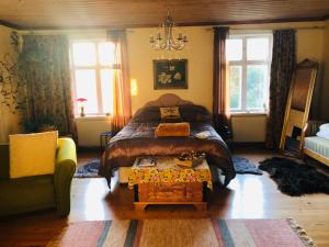 ein Schlafzimmer mit einem Bett, einem Sofa und Fenstern in der Unterkunft Captivating 1-Bed Studio in Avesta