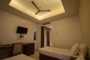 a room with a ceiling fan and a desk and a bed at TANTRA BOUTIQUE HOTEL in Imphal