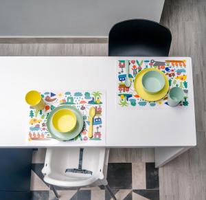 a white table with a chair and two plates on it at Salina Premium Residences Volos in Volos