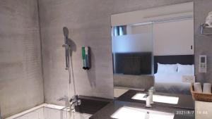 礁溪鄉的住宿－沐谷親子溫泉會館，浴室设有淋浴、两个盥洗盆和镜子