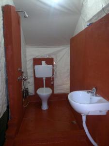 - une salle de bains pourvue d'un lavabo et de toilettes dans une tente dans l'établissement Nature Camp Konark Retreat, à Konârak