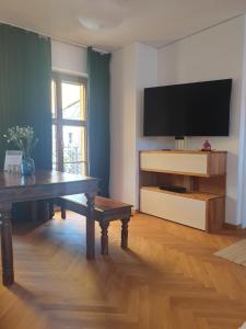 ein Wohnzimmer mit einem Tisch und einem Flachbild-TV in der Unterkunft Modernes Apartment an der Frauenkirche in Dresden