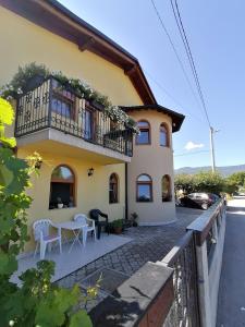 a house with a balcony and a table at Garden Blue Sarajevo - free Parking in Sarajevo