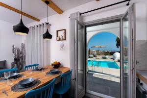 a dining room with a table and chairs and a view of a pool at Modern Dome Homes Of Santorini in Perissa