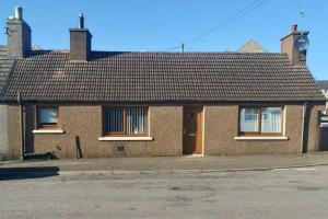 a brick house with a brown roof on a street at 5 Riverside Place Thurso. 2 bed, 2 bathrooms. in Thurso