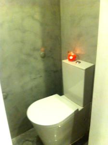 een badkamer met een wit toilet en een rode kaars bij New House Design, Typical Lisbon in Lissabon