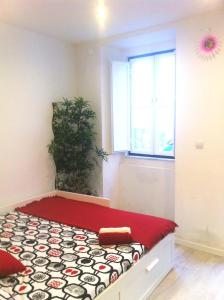 a bedroom with a bed with a red and black bedspread at New House Design, Typical Lisbon in Lisbon