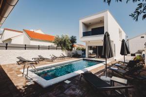 a villa with a swimming pool and a house at Villa Nola with Heated Swimming Pool in Vodice