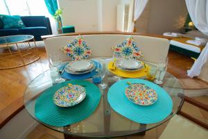 a glass table with plates and glasses on top of it at Hostunia in Ostuni