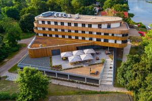 an external view of a building with a table and umbrella at Das ELB Boardinghouse Hotel Restaurant in Magdeburg