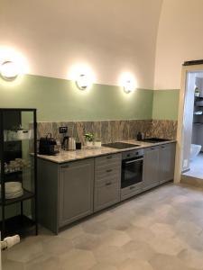 una cocina con electrodomésticos de acero inoxidable y paredes verdes en Caves Apartment en Bari