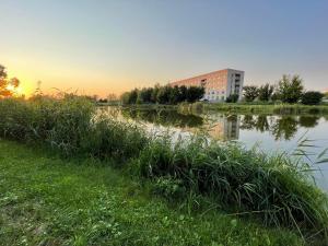 uma massa de água com um edifício ao fundo em Смарт-квартира біля озера em Vinnytsya